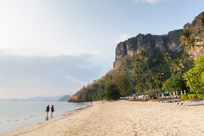 Jong paar die op Pai Plong-strand bij zonsondergang in Krabi-provincie, Thailand lopen stock afbeelding Jong paar die op Pai Plong-strand bij zonsondergang in Krabi-provincie, Thailand lopen stock afbeelding