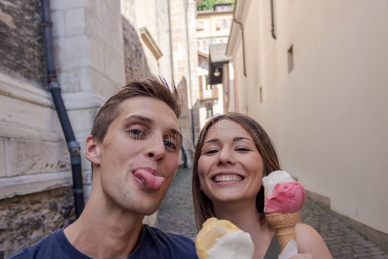 Jong paar die roomijs in een steeg eten royalty-vrije stock fotografie Jong paar die roomijs in een steeg eten royalty-vrije stock fotografie
