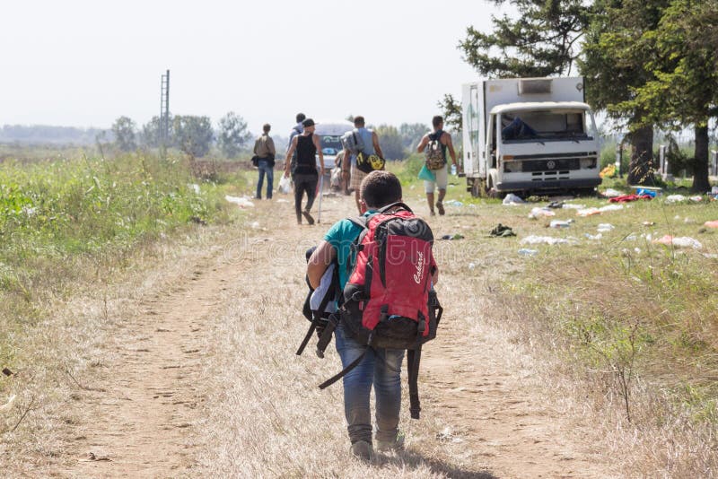 Jong vluchtelingskind die zware rugzak op de grens van Kroatië Servië, tussen steden van Sid & Tovarnik op de Route van de Balkan royalty-vrije stock fotografie Jong vluchtelingskind die zware rugzak op de grens van Kroatië Servië, tussen steden van Sid & Tovarnik op de Route van de Balkan royalty-vrije stock fotografie