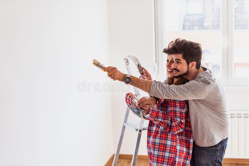 Jong vrolijk paar die kleur voor het schilderen van huis kiezen royalty-vrije stock foto Jong vrolijk paar die kleur voor het schilderen van huis kiezen royalty-vrije stock foto