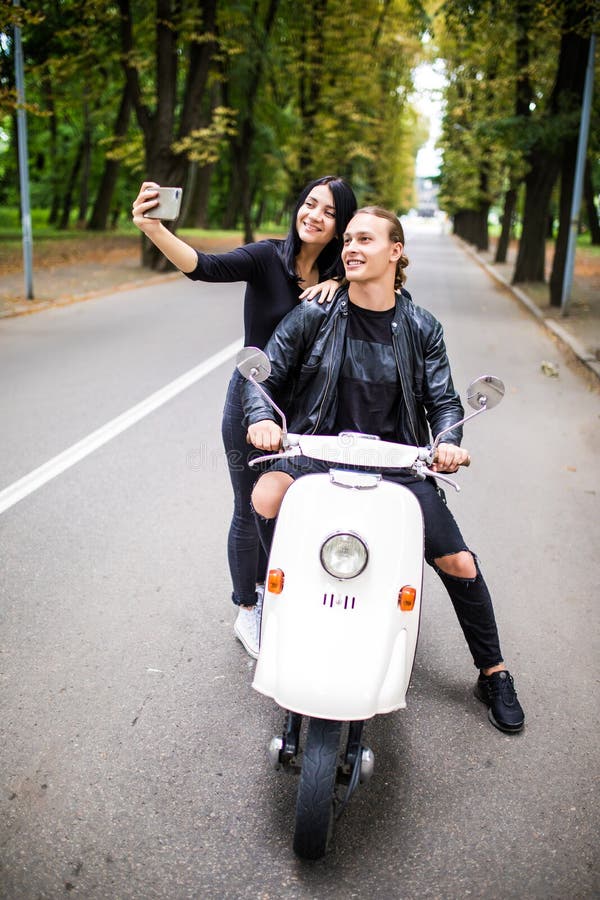 Jong vrolijk paar van toerist op een uitstekende autoped in de stad, royalty-vrije stock foto Jong vrolijk paar van toerist op een uitstekende autoped in de stad, royalty-vrije stock foto