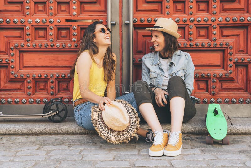 Jong vrouwen vrolijk paar die en elkaar op een rode deurachtergrond kijken glimlachen Zelfde geslachtsgeluk en blij concept stock foto's Jong vrouwen vrolijk paar die en elkaar op een rode deurachtergrond kijken glimlachen Zelfde geslachtsgeluk en blij concept stock foto's