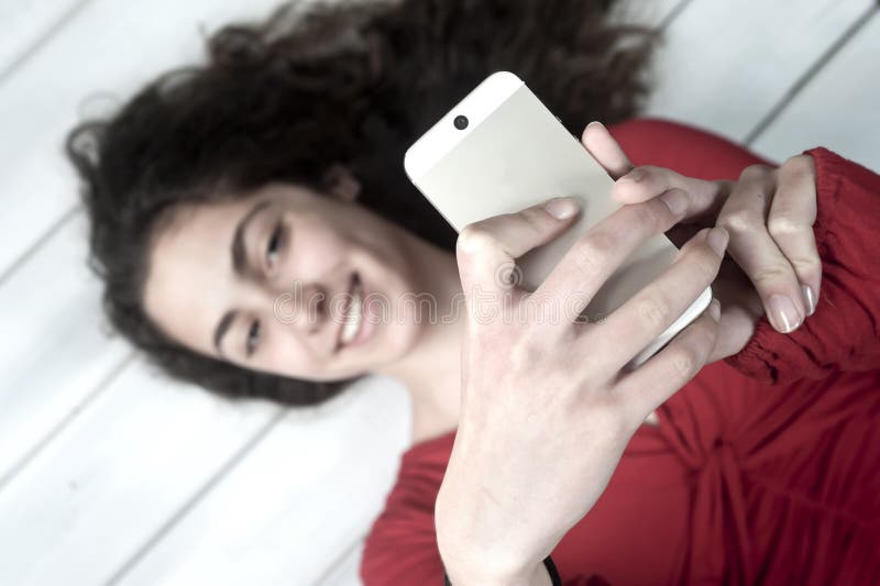 Jong wijfje die op vloer liggen die selfie nemen stock foto's Jong wijfje die op vloer liggen die selfie nemen stock foto's