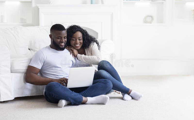 Jong zwart koppel met laptop op de zomervakantie thuis stock fotografie Jong zwart koppel met laptop op de zomervakantie thuis stock fotografie