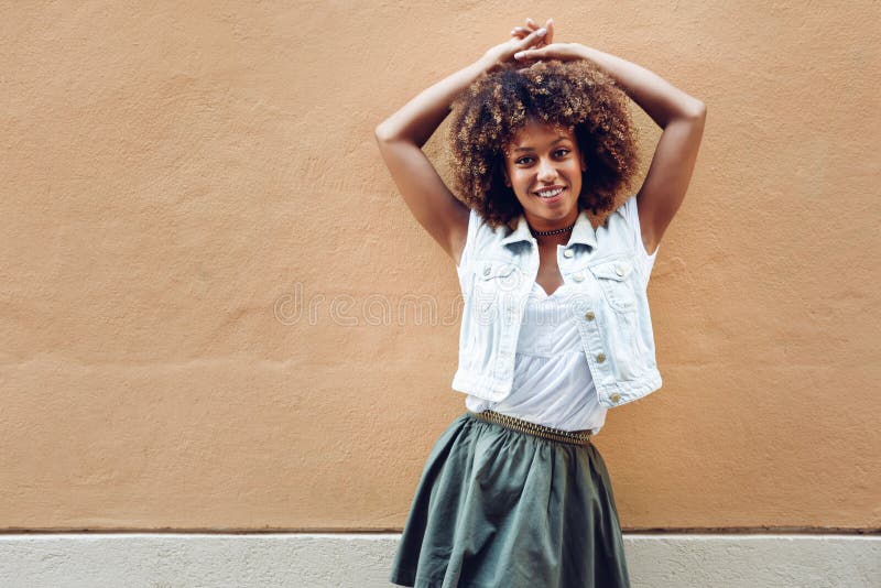 Jong zwarte, afrokapsel, die op stedelijke achtergrond glimlachen stock fotografie Jong zwarte, afrokapsel, die op stedelijke achtergrond glimlachen stock fotografie