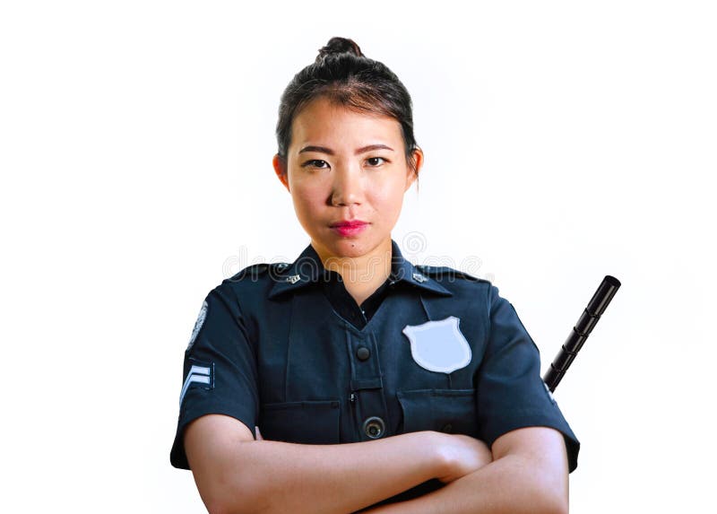 Jonge aantrekkelijke en uitdagende Aziatische Chinese politieman in de eenvormige ernstige stok van de holdingsdefensie geïsoleer stock fotografie Jonge aantrekkelijke en uitdagende Aziatische Chinese politieman in de eenvormige ernstige stok van de holdingsdefensie geïsoleer stock fotografie