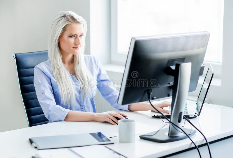 Jonge, aantrekkelijke en zekere vrouw die in bureau werken royalty-vrije stock fotografie Jonge, aantrekkelijke en zekere vrouw die in bureau werken royalty-vrije stock fotografie