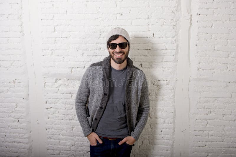 Jonge aantrekkelijke hipster en in stijl die mens stellen koel met zich houding informeel kleden kijken stock afbeeldingen Jonge aantrekkelijke hipster en in stijl die mens stellen koel met zich houding informeel kleden kijken stock afbeeldingen