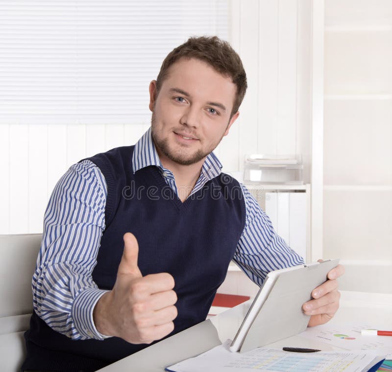 Jonge aantrekkelijke succesvolle manager met duim omhoog op kantoor. stock fotografie Jonge aantrekkelijke succesvolle manager met duim omhoog op kantoor. stock fotografie