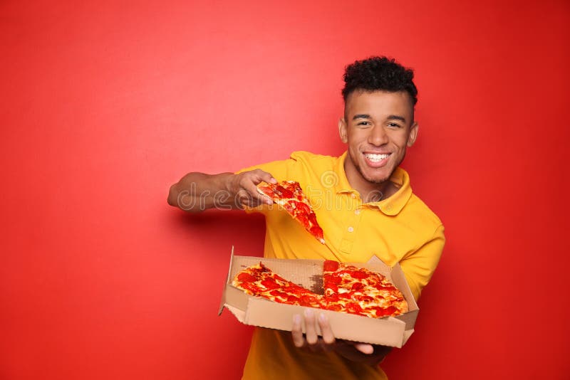 Jonge Afrikaans-Amerikaanse mens die heerlijke pizza op kleurenachtergrond eten royalty-vrije stock fotografie Jonge Afrikaans-Amerikaanse mens die heerlijke pizza op kleurenachtergrond eten royalty-vrije stock fotografie