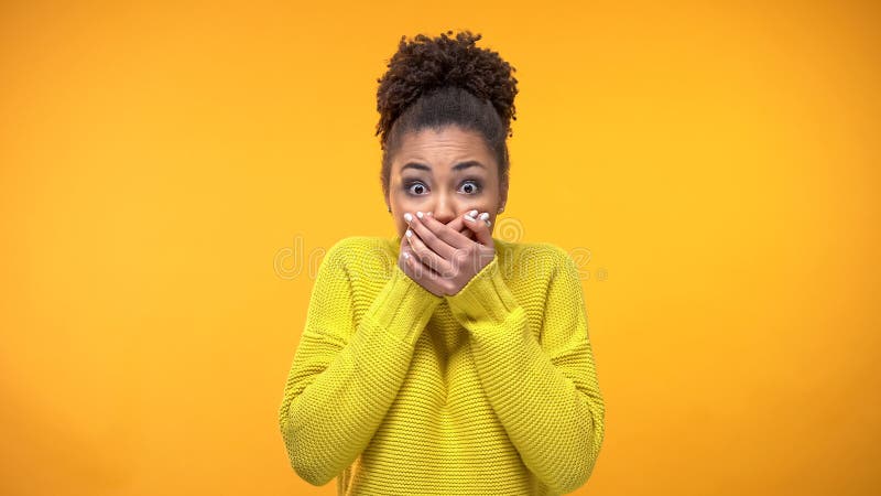 Jonge Afrikaans-Amerikaanse vrouwen sluitende mond met handen, die geheim, roddel houden royalty-vrije stock afbeeldingen Jonge Afrikaans-Amerikaanse vrouwen sluitende mond met handen, die geheim, roddel houden royalty-vrije stock afbeeldingen