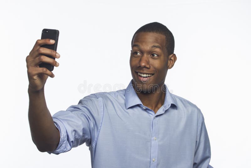 Jonge Afrikaanse Amerikaan die een selfiebeeld met horizontale smartphone nemen, royalty-vrije stock afbeeldingen Jonge Afrikaanse Amerikaan die een selfiebeeld met horizontale smartphone nemen, royalty-vrije stock afbeeldingen
