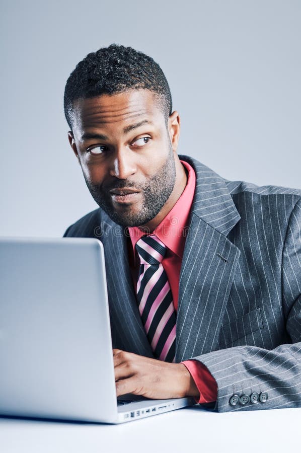 Jonge Afrikaanse Amerikaanse Laptop van Zakenmanbeing sneaky on royalty-vrije stock afbeeldingen Jonge Afrikaanse Amerikaanse Laptop van Zakenmanbeing sneaky on royalty-vrije stock afbeeldingen