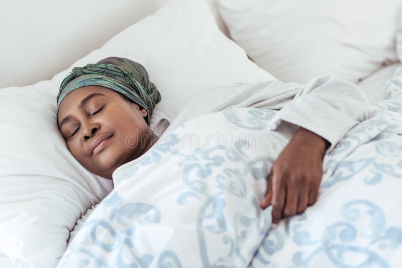 Jonge Afrikaanse vrouw die in haar liggen snel in slaap bed royalty-vrije stock afbeeldingen Jonge Afrikaanse vrouw die in haar liggen snel in slaap bed royalty-vrije stock afbeeldingen