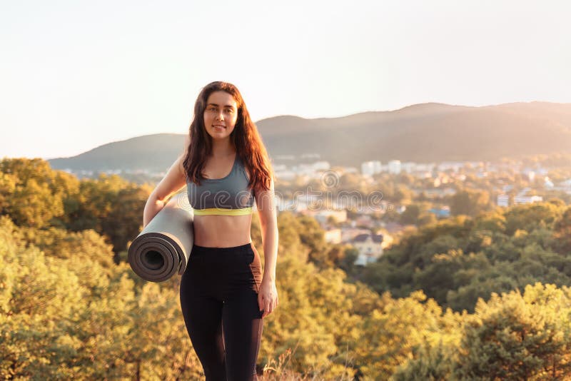 Jonge atletische vrouw die een yogamat houden Concept sport, fitness en gezonde levensstijl De ruimte van het exemplaar royalty-vrije stock afbeeldingen Jonge atletische vrouw die een yogamat houden Concept sport, fitness en gezonde levensstijl De ruimte van het exemplaar royalty-vrije stock afbeeldingen