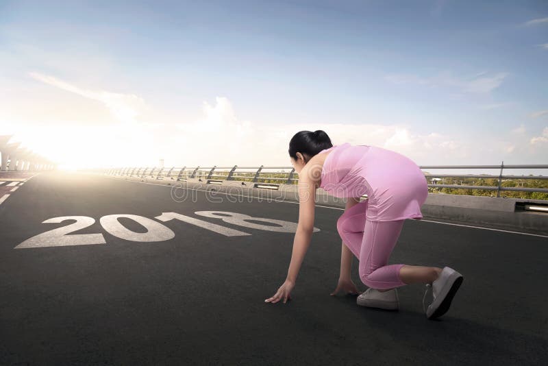 Jonge Aziatische atletenvrouw klaar aan het lopen met het aantal van 2018 stock foto's Jonge Aziatische atletenvrouw klaar aan het lopen met het aantal van 2018 stock foto's