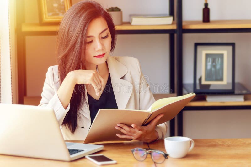 Jonge Aziatische bedrijfsvrouw die op het werk werken stock fotografie Jonge Aziatische bedrijfsvrouw die op het werk werken stock fotografie