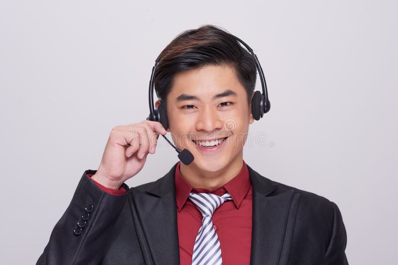 Jonge Aziatische mens in kostuum die een hoofdtelefoon dragen