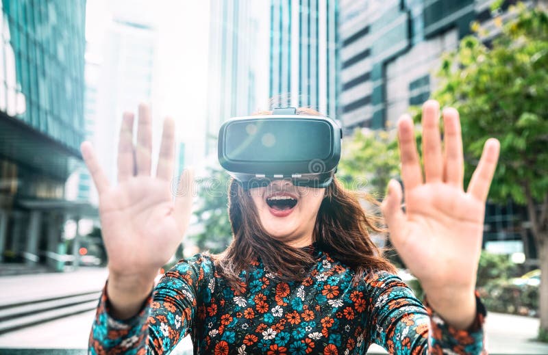 Jonge aziatische vrouw die in de moderne stad een bril ervaart - Virtuele realiteit en een draagbaar technologisch concept met ee stock foto Jonge aziatische vrouw die in de moderne stad een bril ervaart - Virtuele realiteit en een draagbaar technologisch concept met ee stock foto