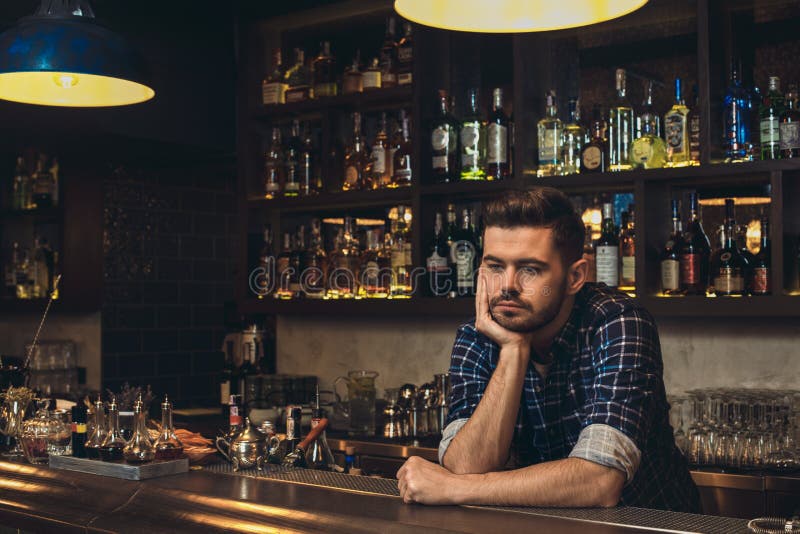 Jonge barman die op nadenkende barteller leunen royalty-vrije stock fotografie Jonge barman die op nadenkende barteller leunen royalty-vrije stock fotografie