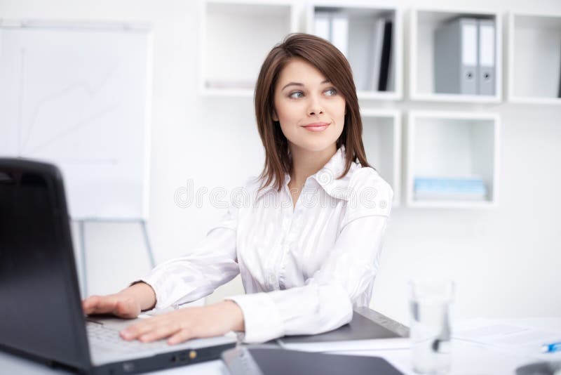 Jonge bedrijfsvrouwenzitting bij bureau op kantoor stock fotografie Jonge bedrijfsvrouwenzitting bij bureau op kantoor stock fotografie