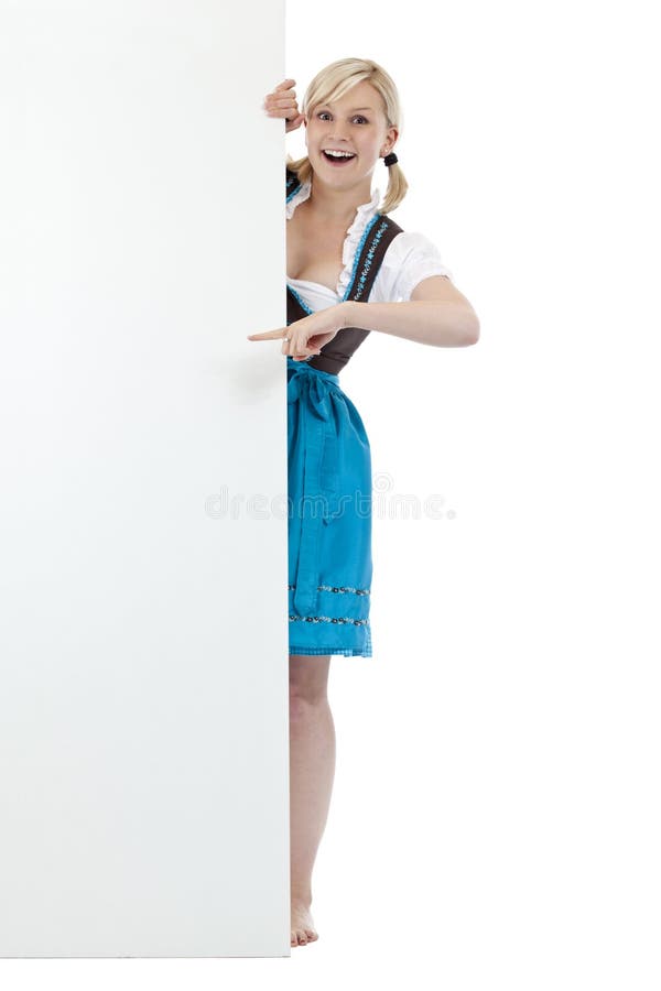 Jonge, blonde vrouw in dirndl die op aanplakbord richten stock fotografie Jonge, blonde vrouw in dirndl die op aanplakbord richten stock fotografie