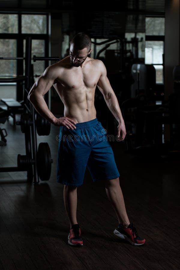 Jonge Bodybuilder die Oogglazen dragen die Spieren buigen royalty-vrije stock afbeelding Jonge Bodybuilder die Oogglazen dragen die Spieren buigen royalty-vrije stock afbeelding