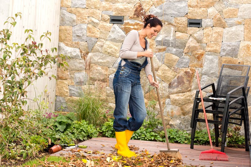 Jonge de bladerenveranda van de vrouwen vegende herfst stock afbeelding Jonge de bladerenveranda van de vrouwen vegende herfst stock afbeelding