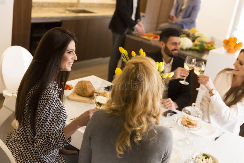 Jonge diner hebben thuis en vrienden die roosteren royalty-vrije stock fotografie Jonge diner hebben thuis en vrienden die roosteren royalty-vrije stock fotografie