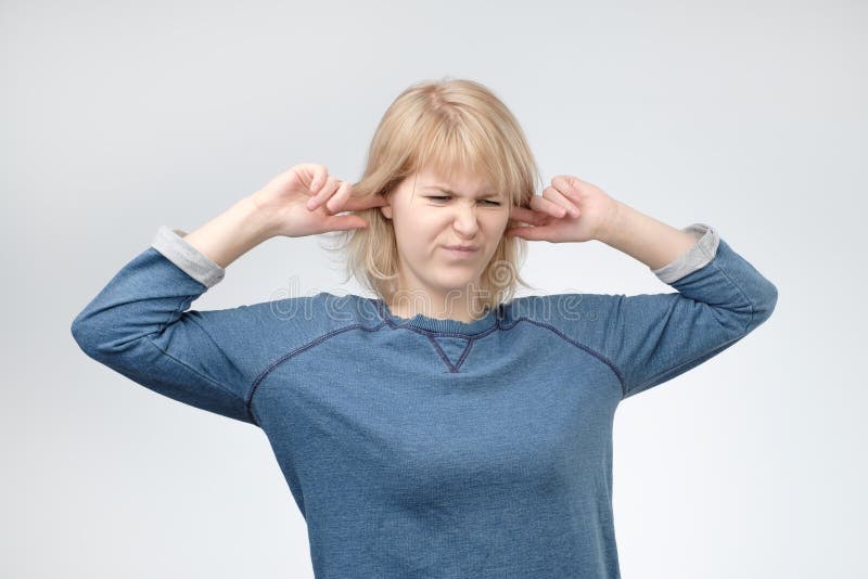 Jonge Europese vrouw die oren stoppen, omhoog kijkend die, beweren niet te horen wat zij wordt verteld royalty-vrije stock foto Jonge Europese vrouw die oren stoppen, omhoog kijkend die, beweren niet te horen wat zij wordt verteld royalty-vrije stock foto