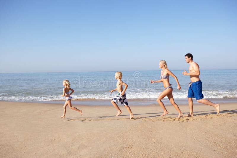 Jonge familie die op strand loopt stock afbeeldingen Jonge familie die op strand loopt stock afbeeldingen