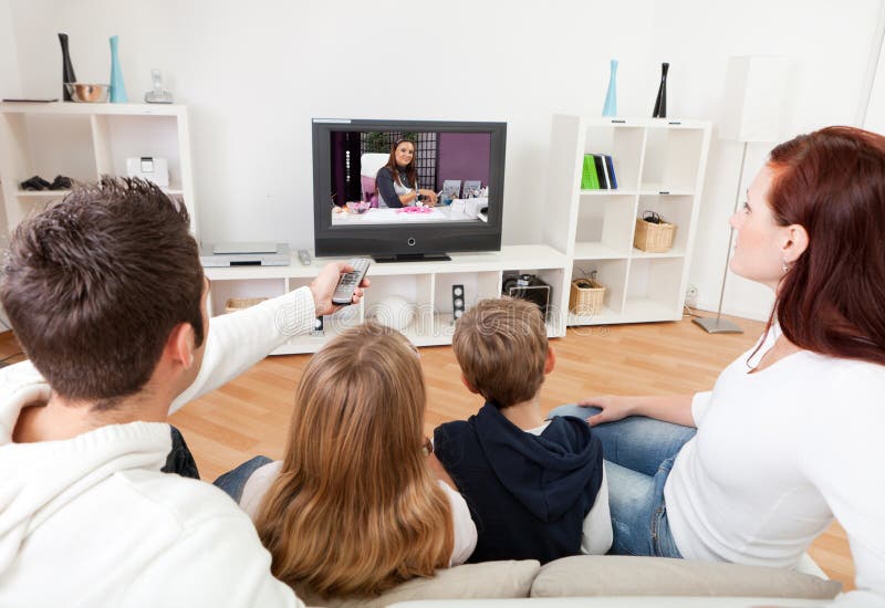 Jonge familie die op TV thuis let