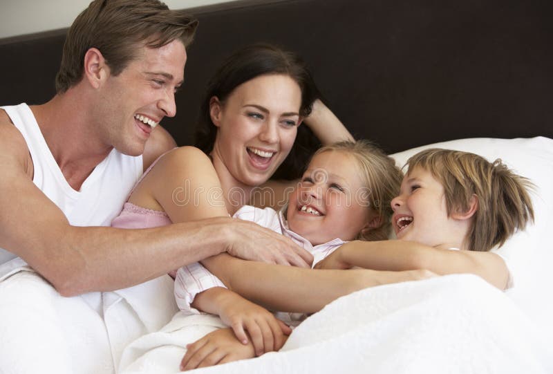 Jonge Familie die Pret in Bed hebben stock foto's Jonge Familie die Pret in Bed hebben stock foto's