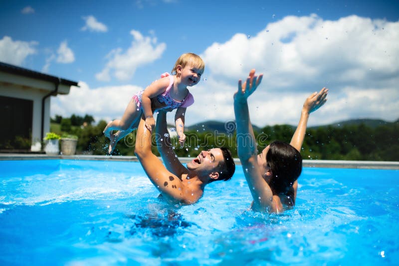Jonge familie met kleine dochter in zwembad in de buitenlucht in hobbytuin.