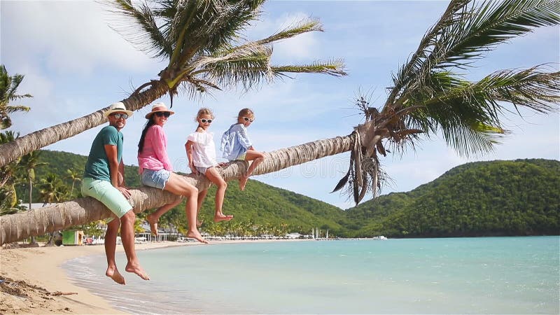 Jonge familie op strandvakantie op palm Ouders en jonge geitjes die pret samen op de kust van de Caraïben op Antigua hebben