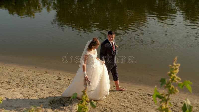 Jonge familie reist op huwelijksreis liefdevol stel gaat hand in hand op strand vrolijke bruid in witte jurk