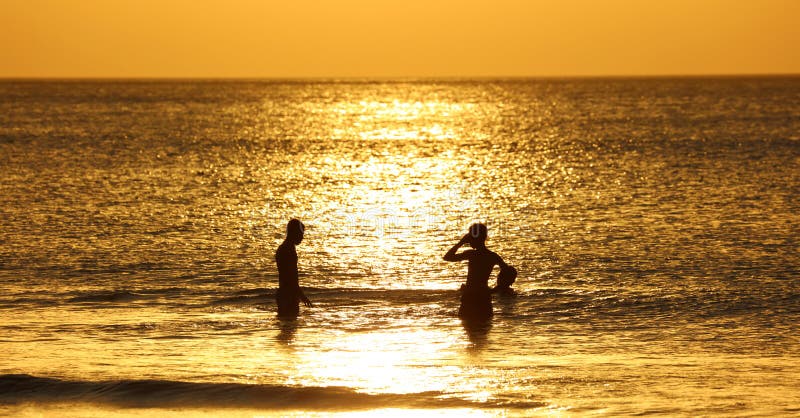Jonge geitjes die bij het strand in Bali, Indonesië tijdens zonsondergang bij het strand spelen royalty-vrije stock foto's Jonge geitjes die bij het strand in Bali, Indonesië tijdens zonsondergang bij het strand spelen royalty-vrije stock foto's