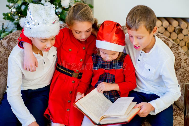 Jonge geitjes die een verhaalboek op Kerstmistijd lezen royalty-vrije stock foto's Jonge geitjes die een verhaalboek op Kerstmistijd lezen royalty-vrije stock foto's