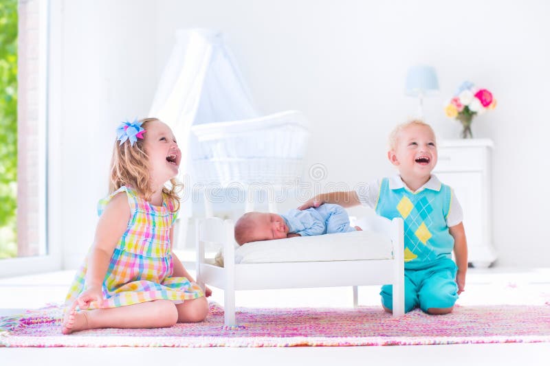 Jonge geitjes die met nieuw spelen - geboren babybroer royalty-vrije stock foto Jonge geitjes die met nieuw spelen - geboren babybroer royalty-vrije stock foto