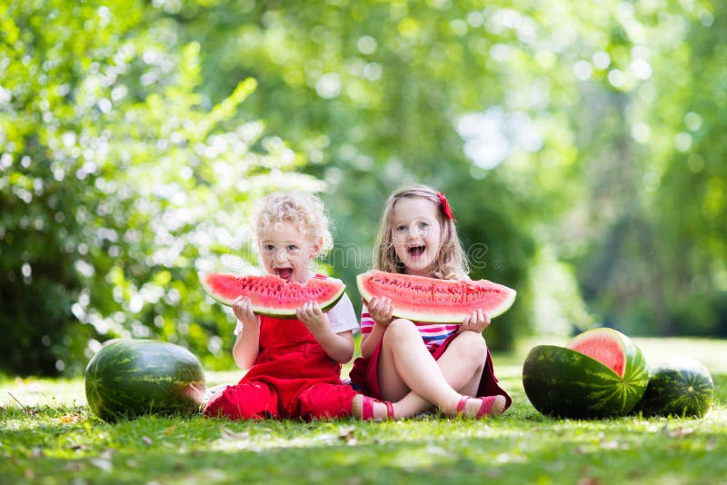 Jonge geitjes die watermeloen in de tuin eten