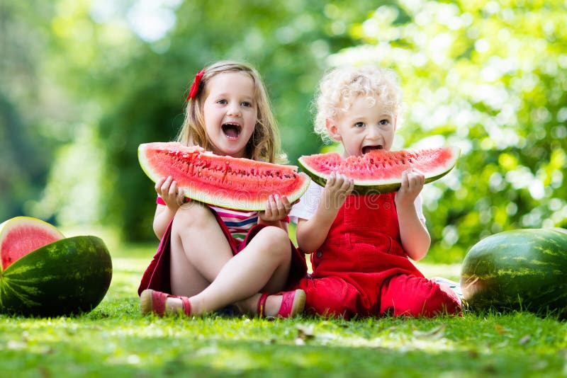 Jonge geitjes die watermeloen in de tuin eten