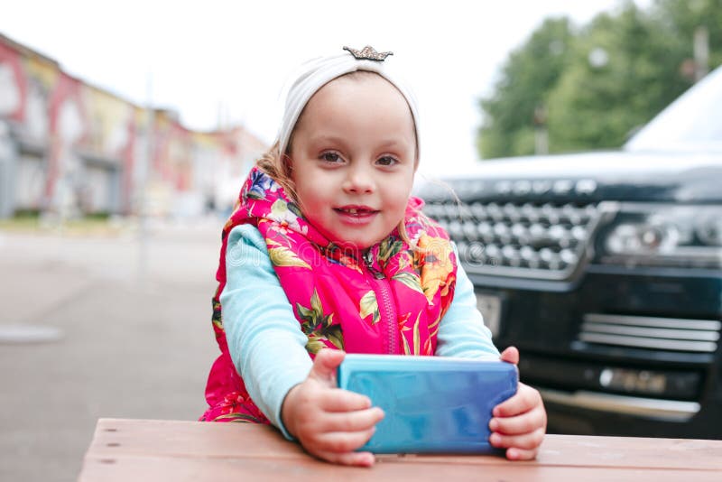 Jonge geitjes gebruikend smartphone Babymeisje die mobiele telefoon spelen openlucht stock afbeeldingen Jonge geitjes gebruikend smartphone Babymeisje die mobiele telefoon spelen openlucht stock afbeeldingen