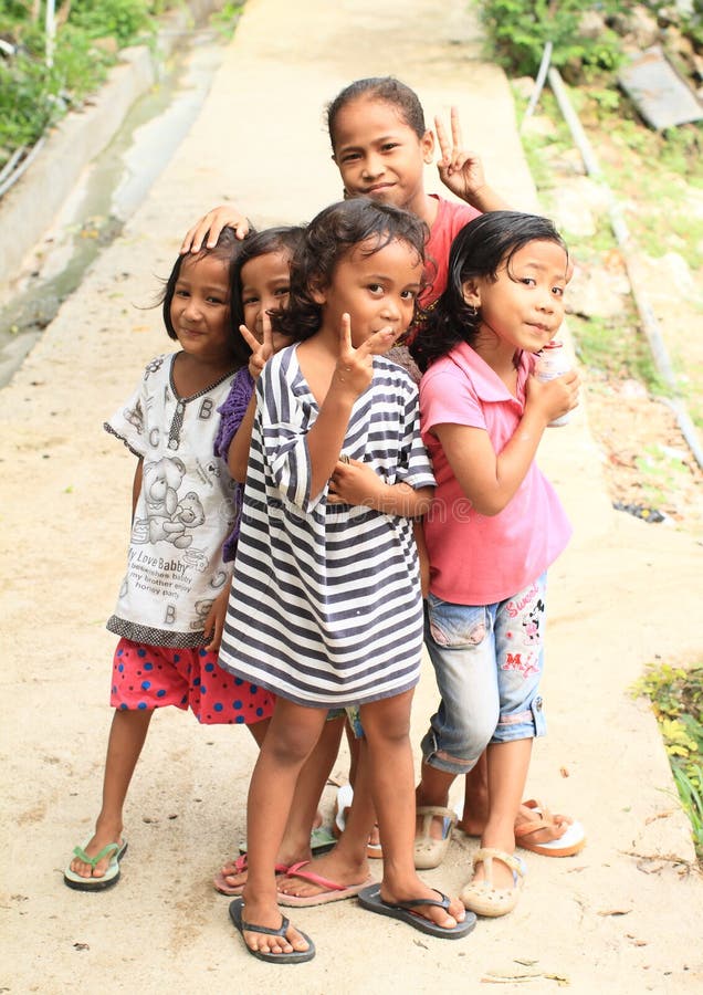 Jonge geitjes - meisjes die op straat van Labuan Bajo stellen stock afbeelding Jonge geitjes - meisjes die op straat van Labuan Bajo stellen stock afbeelding