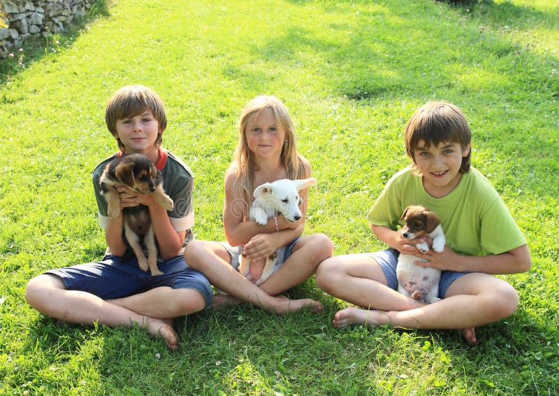 Jonge geitjes met puppy stock afbeeldingen Jonge geitjes met puppy stock afbeeldingen