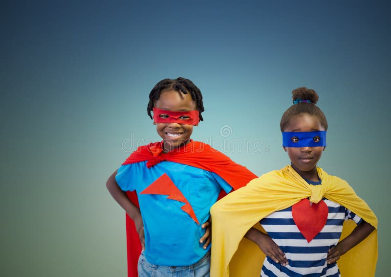 Jonge geitjes in superherokostuum die zich met handen op heupen bevinden stock foto Jonge geitjes in superherokostuum die zich met handen op heupen bevinden stock foto