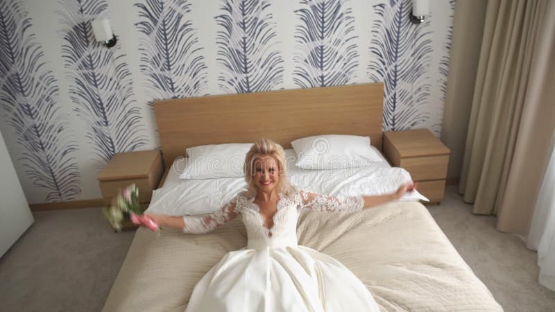 Jonge gelukkige bruidsprong op bed