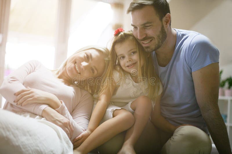 Jonge gelukkige familie die thuis van genieten royalty-vrije stock afbeelding Jonge gelukkige familie die thuis van genieten royalty-vrije stock afbeelding