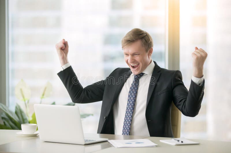 Jonge gelukkige zakenman bij het bureau stock foto Jonge gelukkige zakenman bij het bureau stock foto