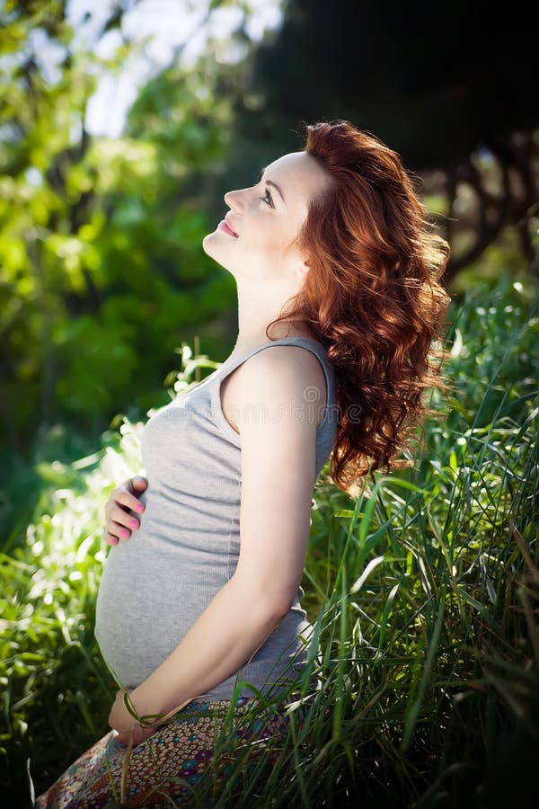 Jonge gelukkige zwangere vrouw die en van het leven in aard ontspannen genieten stock fotografie Jonge gelukkige zwangere vrouw die en van het leven in aard ontspannen genieten stock fotografie