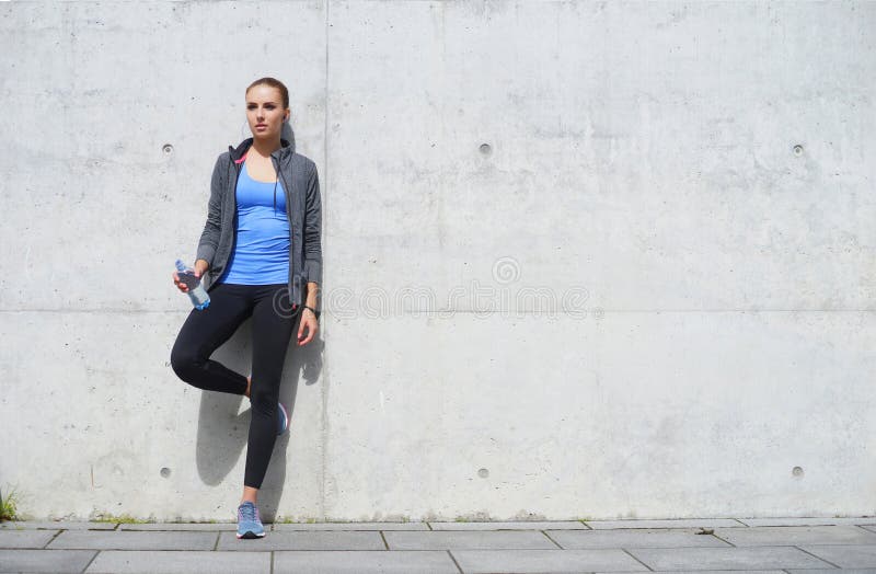 Jonge, geschikte en sportieve vrouw die na de opleiding rusten Fitness, sport, stedelijke jogging en gezond levensstijlconcept stock foto Jonge, geschikte en sportieve vrouw die na de opleiding rusten Fitness, sport, stedelijke jogging en gezond levensstijlconcept stock foto